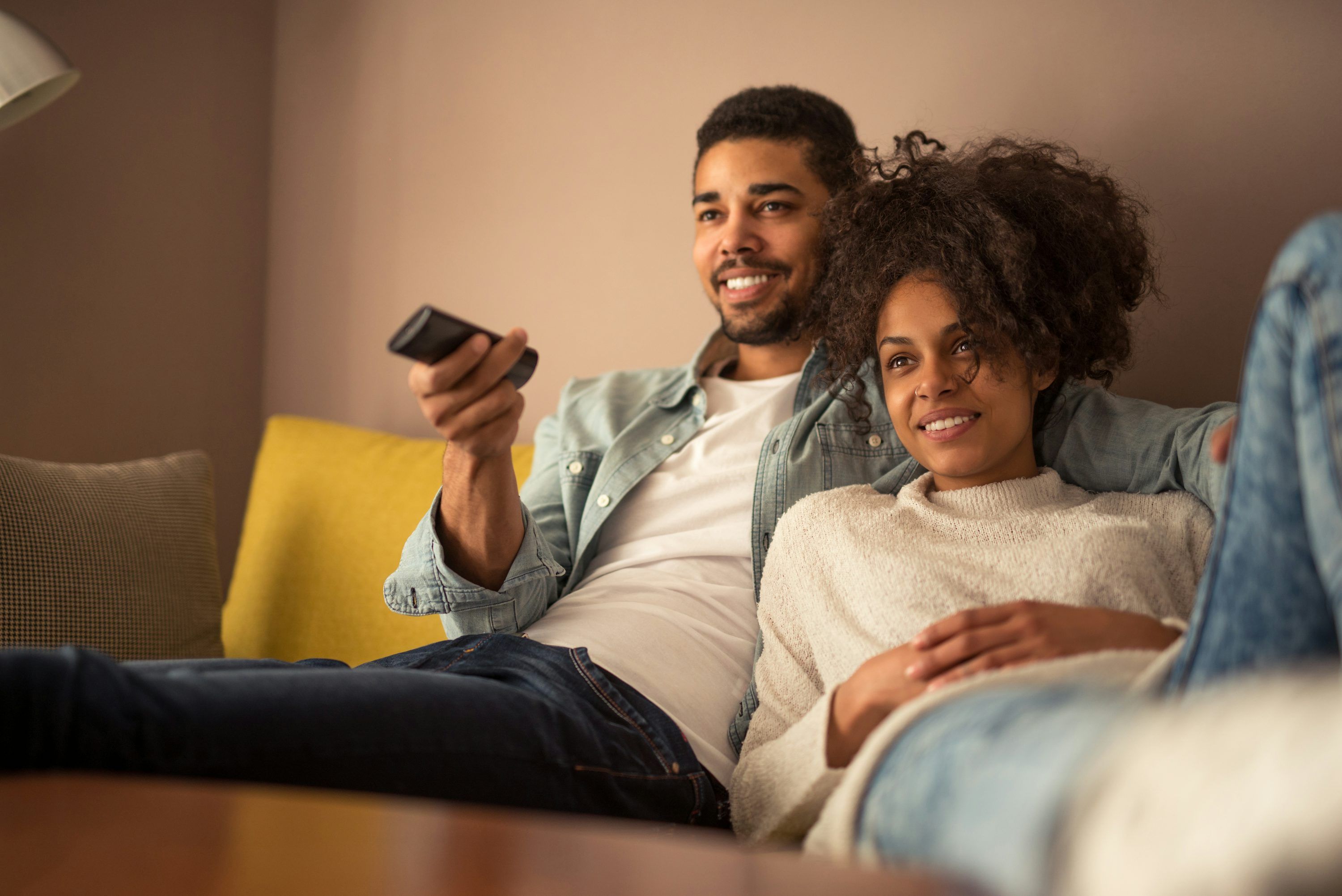 Couple choisissant leur abonnement IPTV sur un ordinateur portable pour regarder la télévision en Suisse